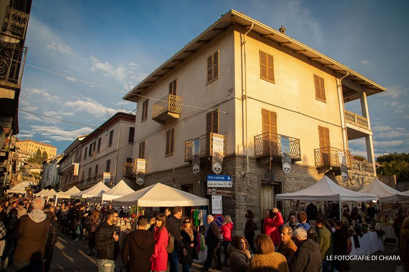 La folla tra i gazebo davanti a un palazzo del borgo